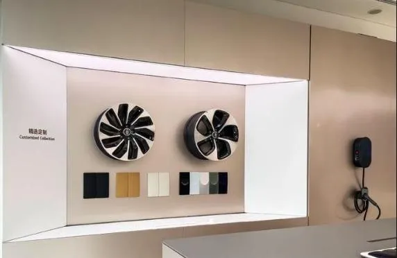 AITO accessory display cabinet with two wheels and colour swatches, lit from above