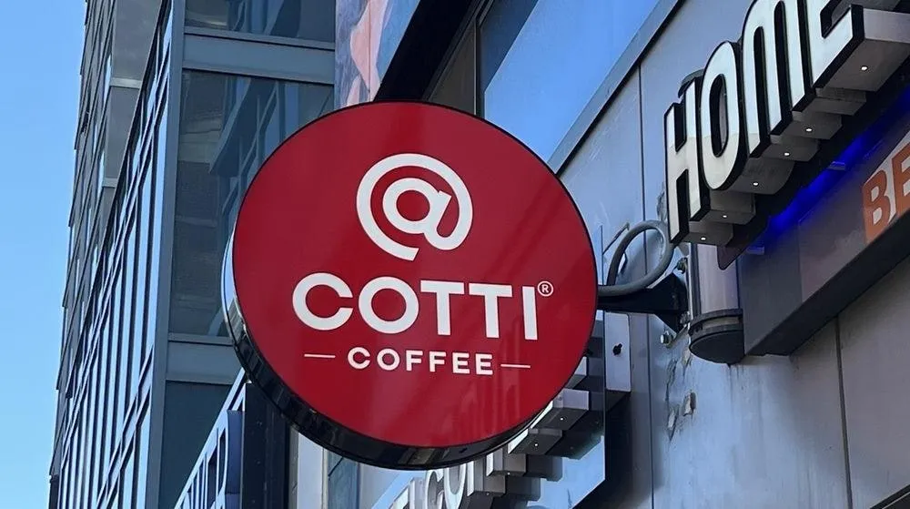 Cotti Coffee round red projecting sign on a glass-fronted building
