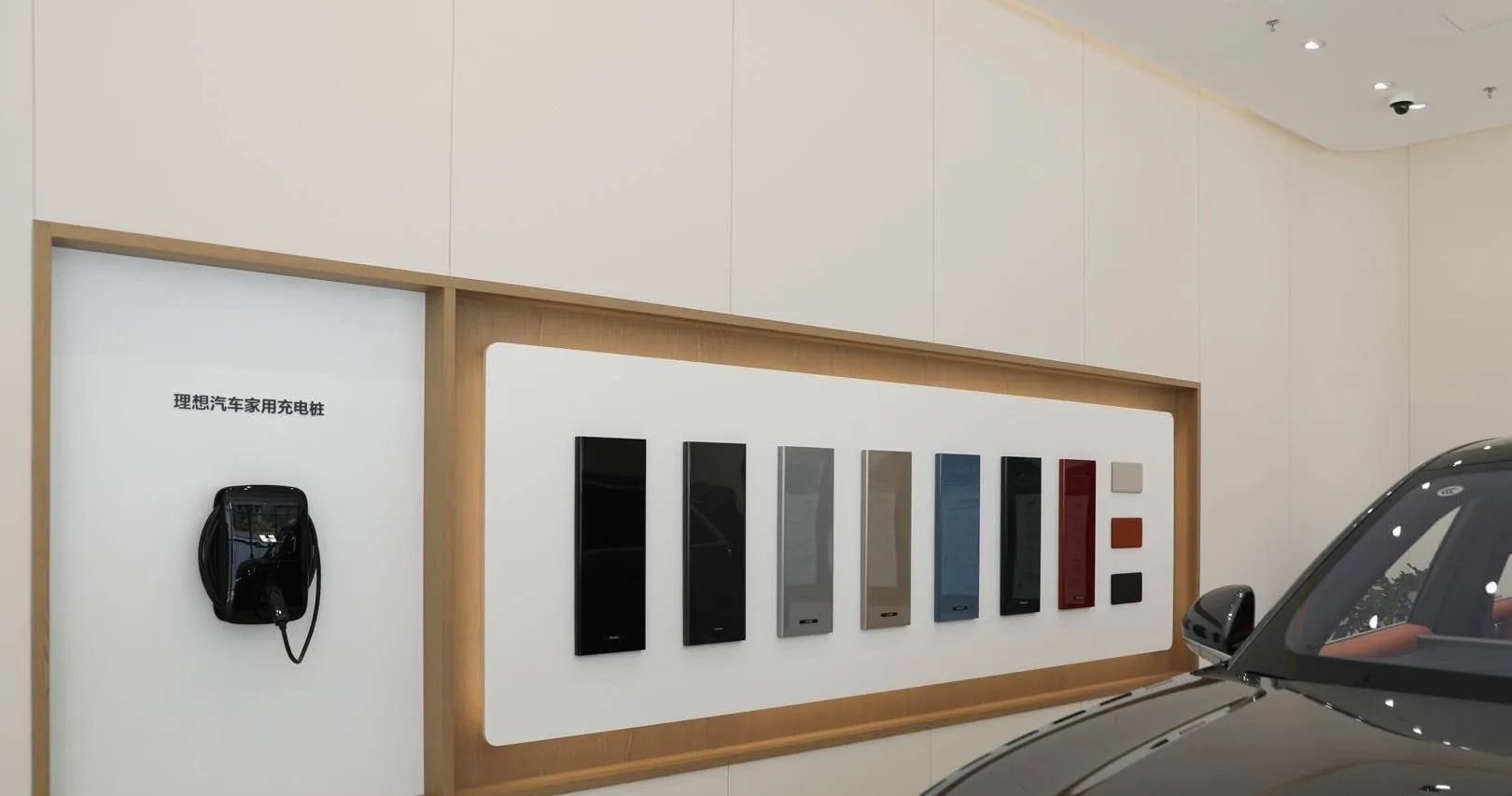Li Auto charging station display wall with a wall charger and a row of colour swatches
