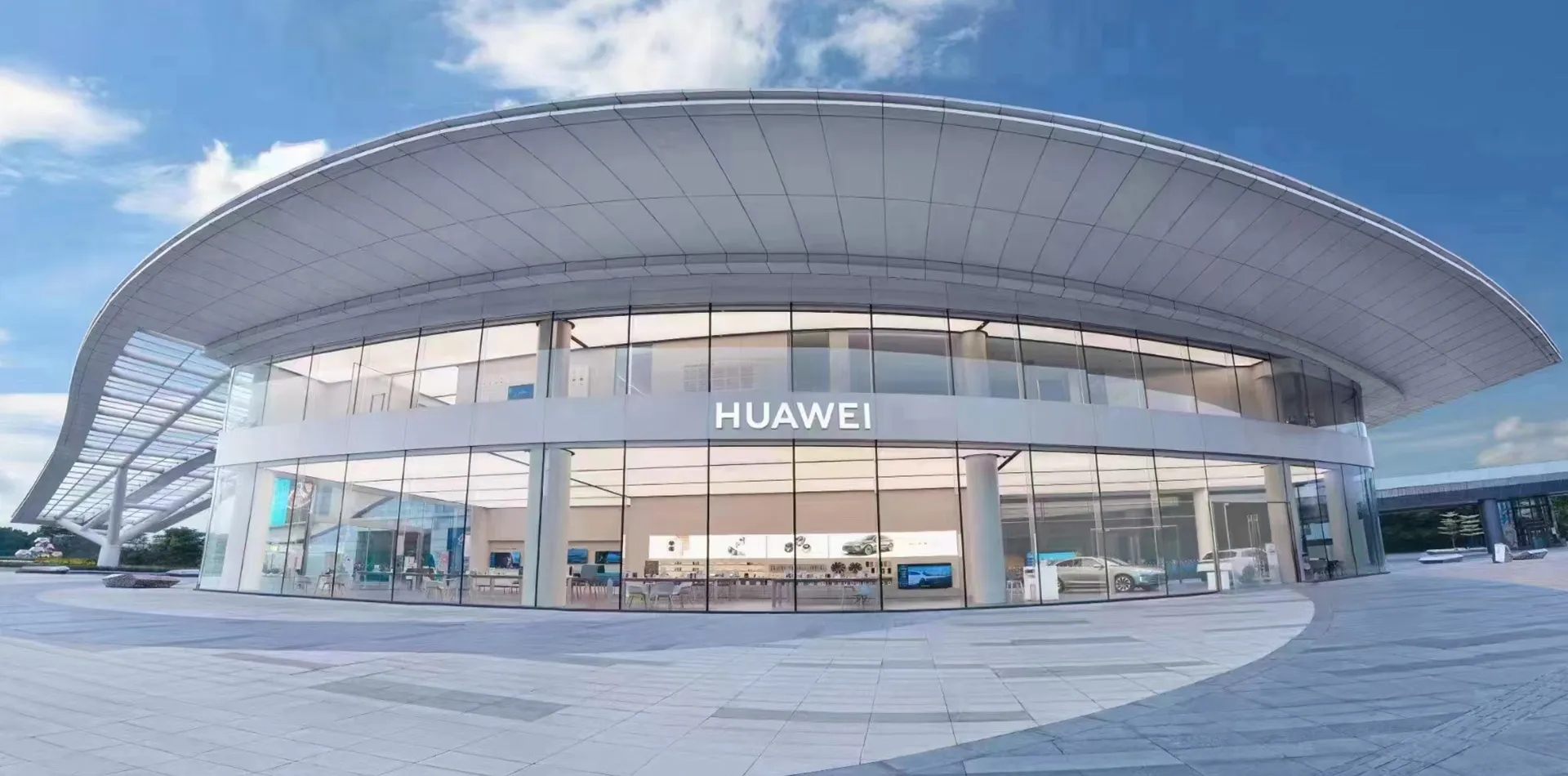 Huawei flagship store — curved roof and full-height glass façade on an open plaza